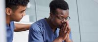 Two nurses expressing burnout in hospital setting.